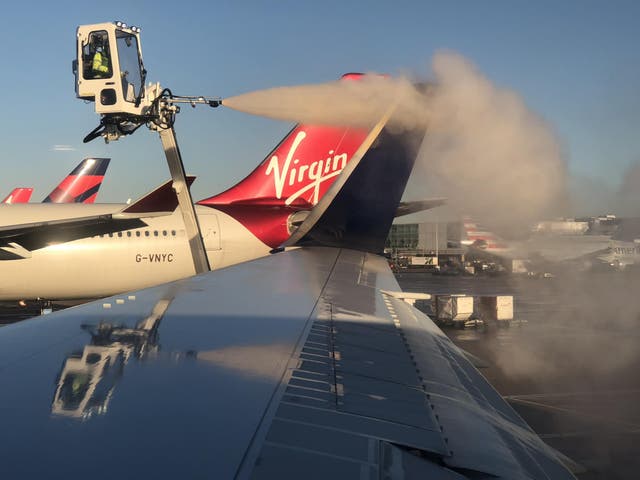 Get set: de-icing the Heathrow-Boston aircraft with a Virgin Atlantic plane in the background