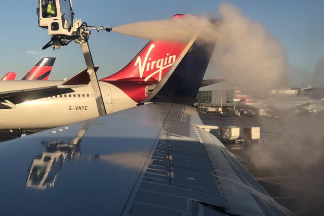 Get set: de-icing the Heathrow-Boston aircraft with a Virgin Atlantic plane in the background