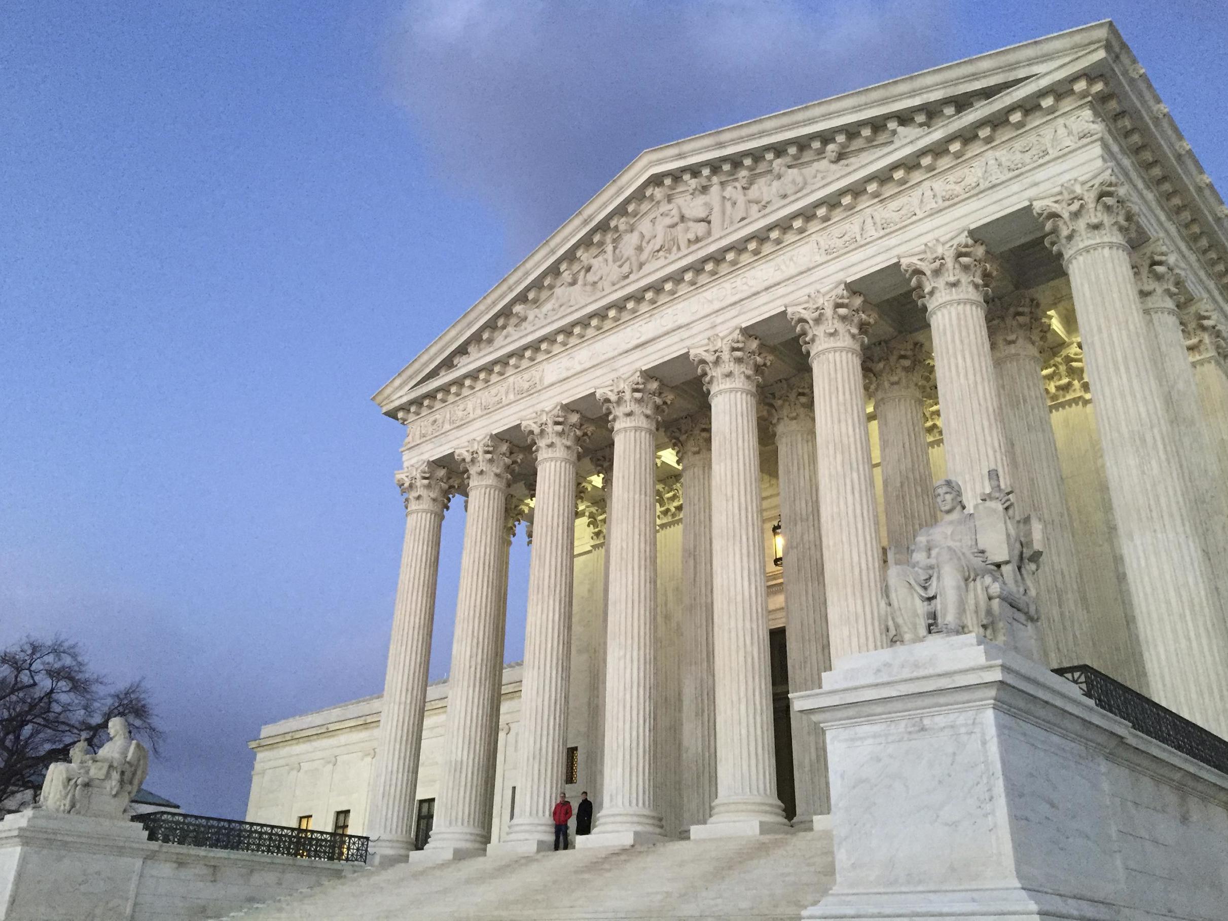 People stand on the steps of the Supreme Court in Washington