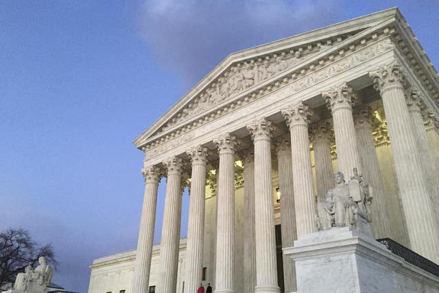 People stand on the steps of the Supreme Court in Washington