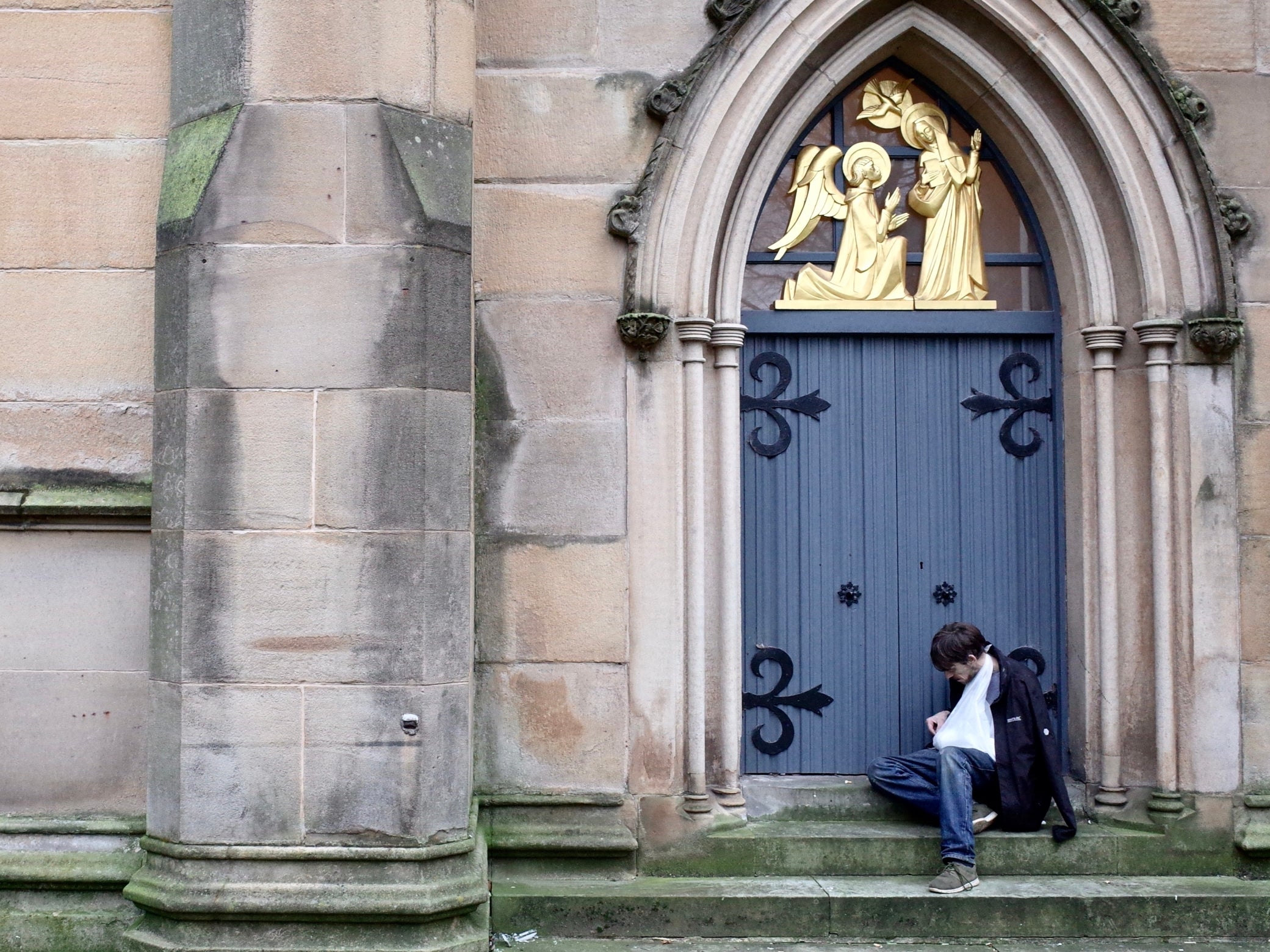 Underneath the angels in Blackburn: a joint in hand and an arm in a sling