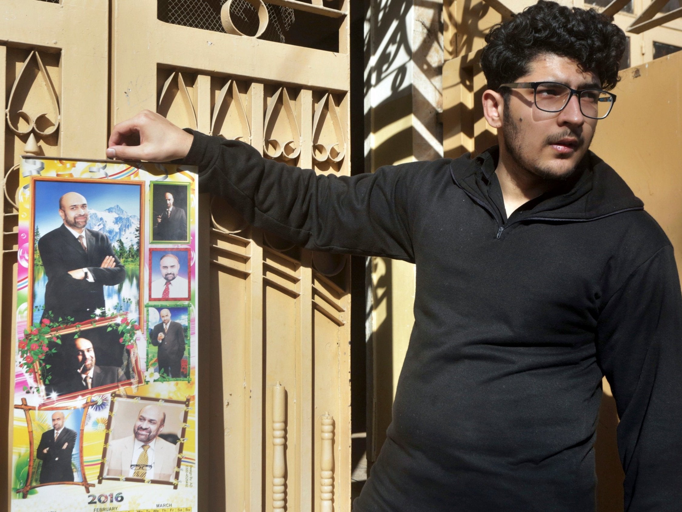 Pictured: Osama Rizi, son of journalist Rizwan-ur-Rehman Razi, displays a calendar with pictures of his father outside his residence in Lahore, Pakistan, Saturday 9 February 2019.