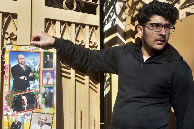 Pictured: Osama Rizi, son of journalist Rizwan-ur-Rehman Razi, displays a calendar with pictures of his father outside his residence in Lahore, Pakistan, Saturday 9 February 2019.