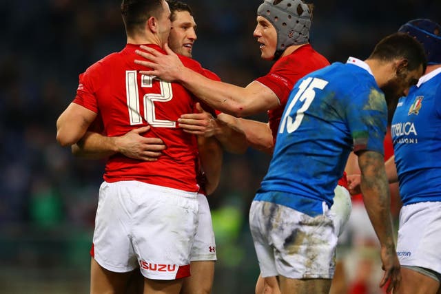 Owen Watkin is congratulated by his Wales teammates after scoring their second try against Italy