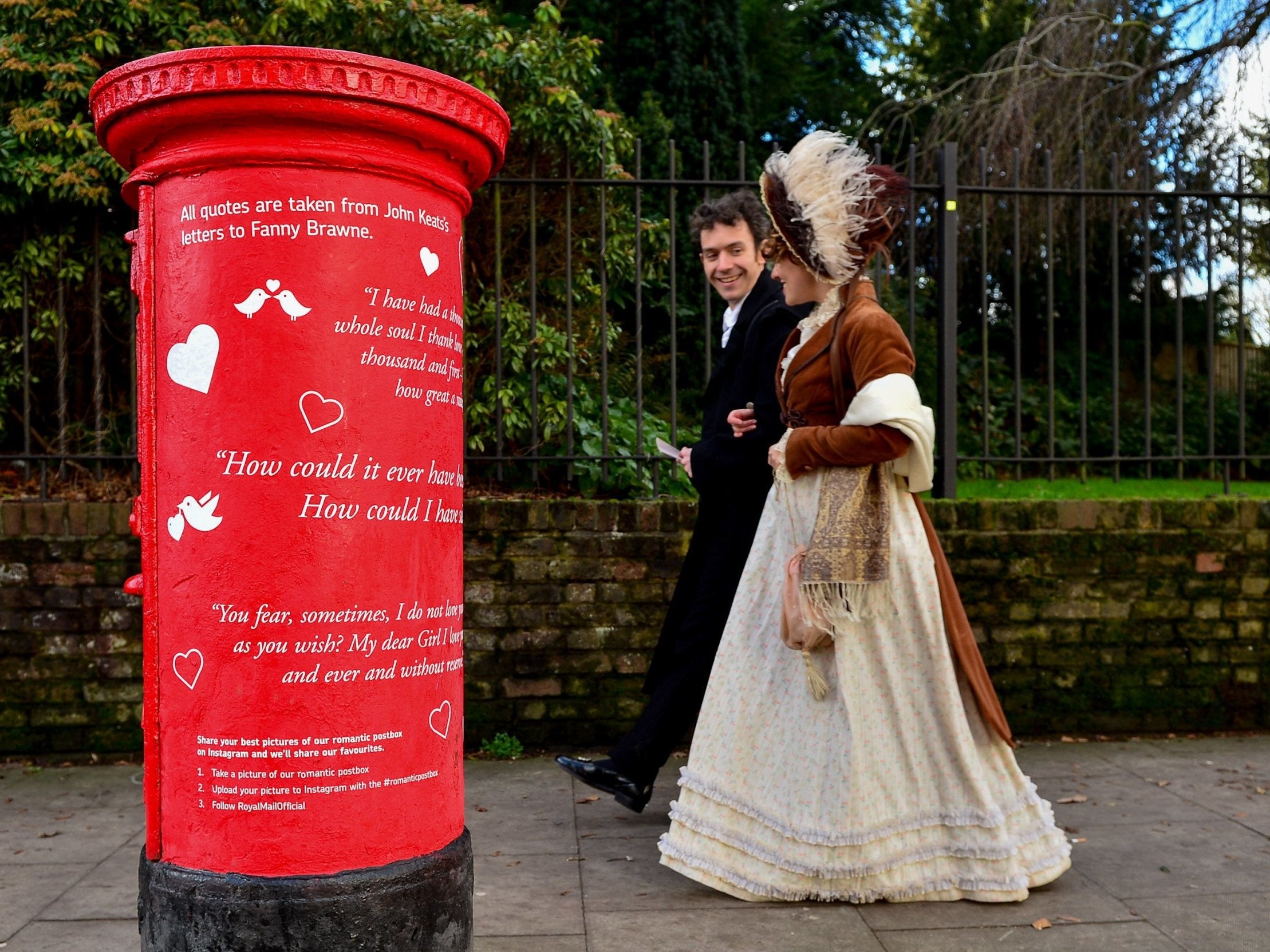 Actors from the Keats Museum walk past one of the adorned boxes