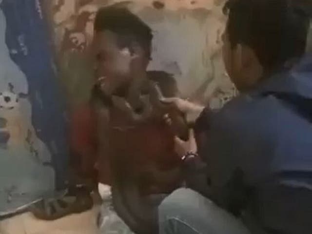 Footage of an officer using a live snake to interrogate a Papuan man