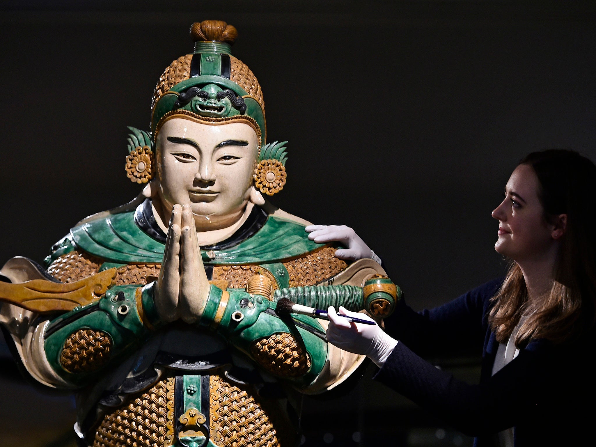 Assistant conservator Margot Murray cleans a statue of Weituo, the leading guardian of Buddhist faith and teachings