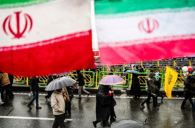 Iranian people carry umbrellas during a ceremony to mark the 40th anniversary of the Islamic Revolution in Tehran