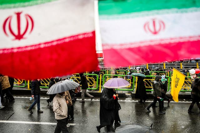 Iranian people carry umbrellas during a ceremony to mark the 40th anniversary of the Islamic Revolution in Tehran