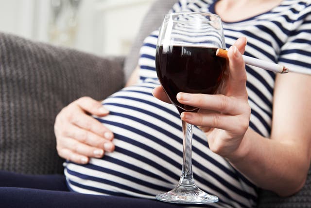 Close Up Of Pregnant Woman Smoking And Drinking