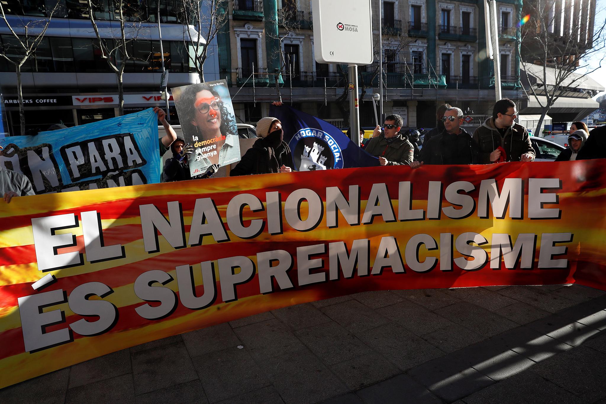 Separatist protesters hold a banner reading "Nationalism is supremacy" outside the Supreme Court in Madrid