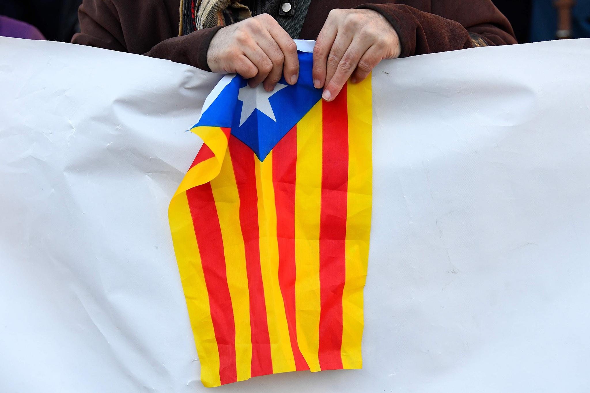A protester holds a Catalan pro-independence Estelada flag during a protest outside the Supreme Court in Madrid