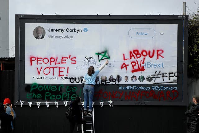 Young campaigners deface a Labour Party billboard, calling for a fresh vote