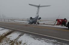 Aircraft slides off snowy runway and crashes onto highway in Indiana