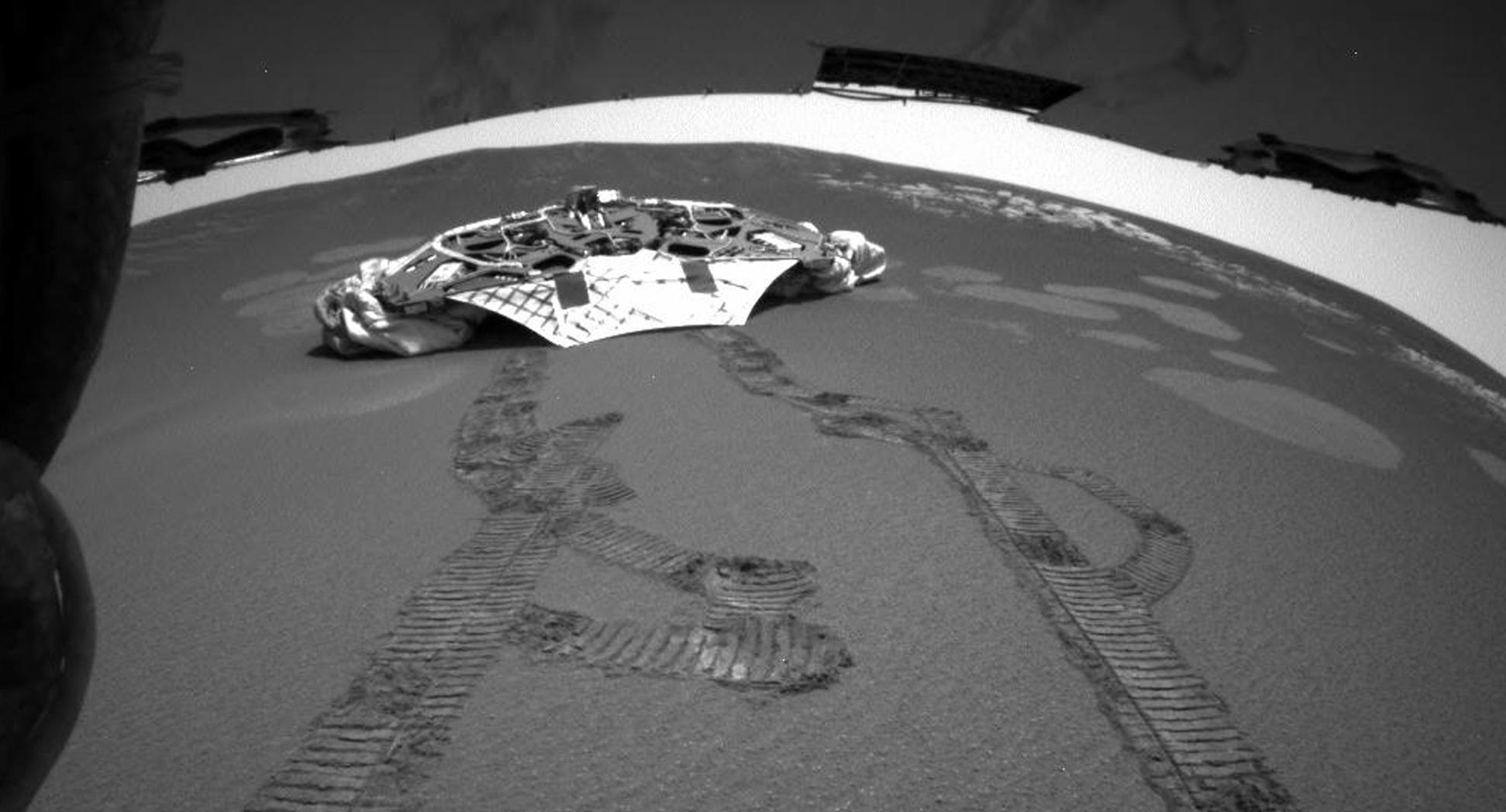 This photo released Thursday, Feb. 5, 2004 made by one of the rear hazard-avoidance cameras on NASA's Opportunity rover, shows Opportunity's landing platform, with freshly made tracks leading away from it