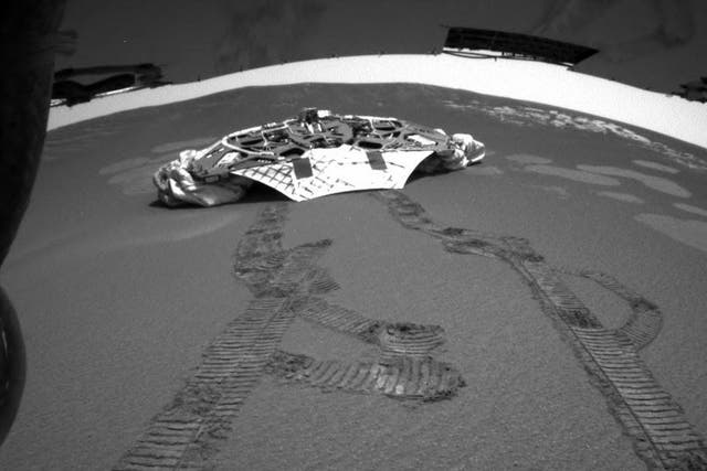 This photo released Thursday, Feb. 5, 2004 made by one of the rear hazard-avoidance cameras on NASA's Opportunity rover, shows Opportunity's landing platform, with freshly made tracks leading away from it