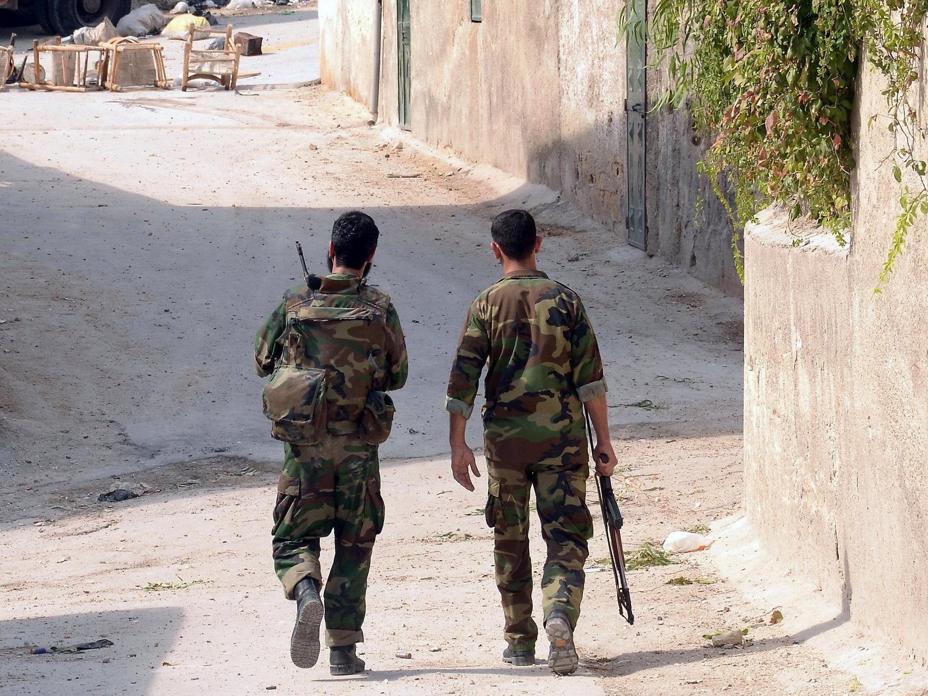 Two soldiers from a unit of the Syrian armed forces carry out a military operation in 2012 (file photo)