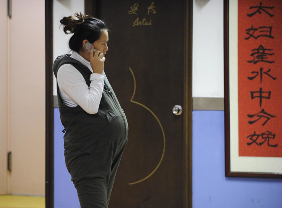 A pregnant woman speaks on the phone in Beijing