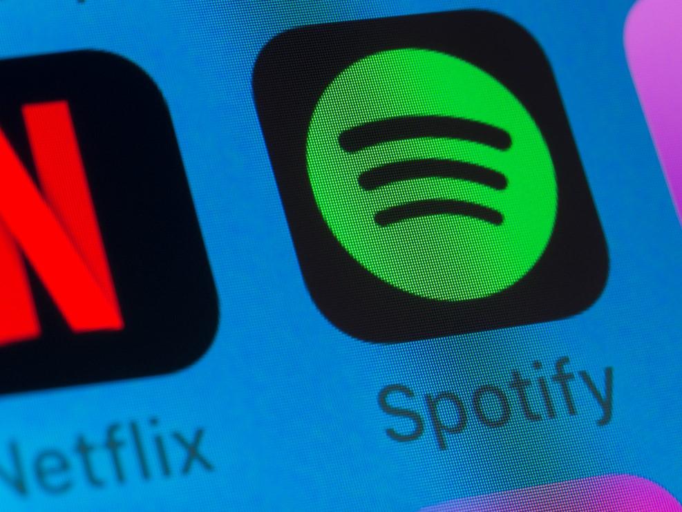Netflix and Spotify apps appear on the screen of an iPhone