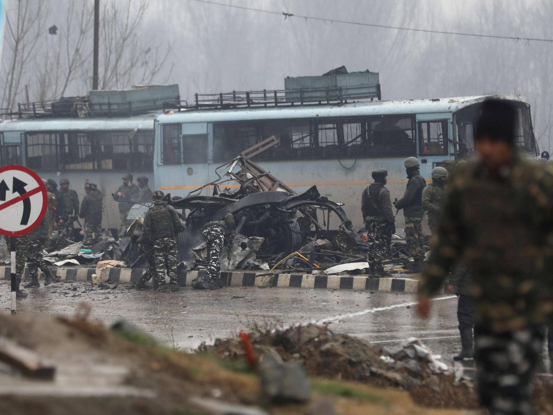 Indian security men inspect the site of the Pulwama attack in 2019