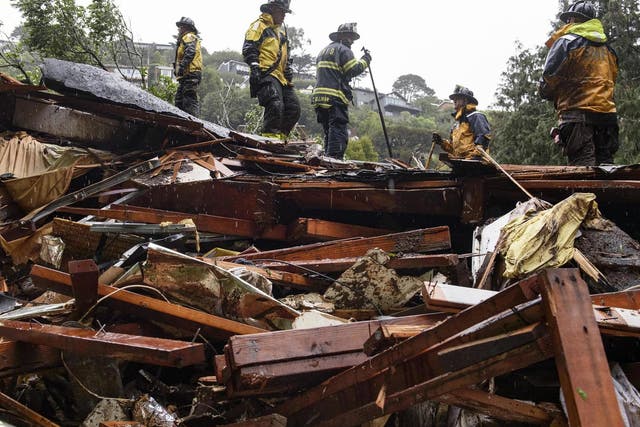 Southern Marin Fire Department members search a crushed house in the aftermath of a mudslide that destroyed three homes on a hillside in Sausalito, Calif., Thursday 14 February 2019.
