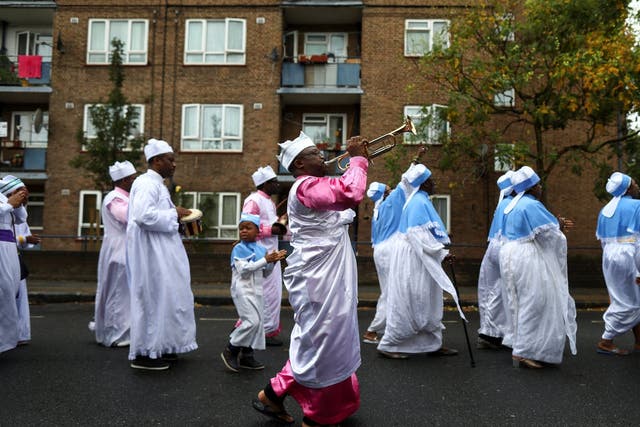 Members of the Eternal Sacred Order of Cherubim & Seraphim parade through the street to celebrate their annual Thanksgiving in Elephant and Castle