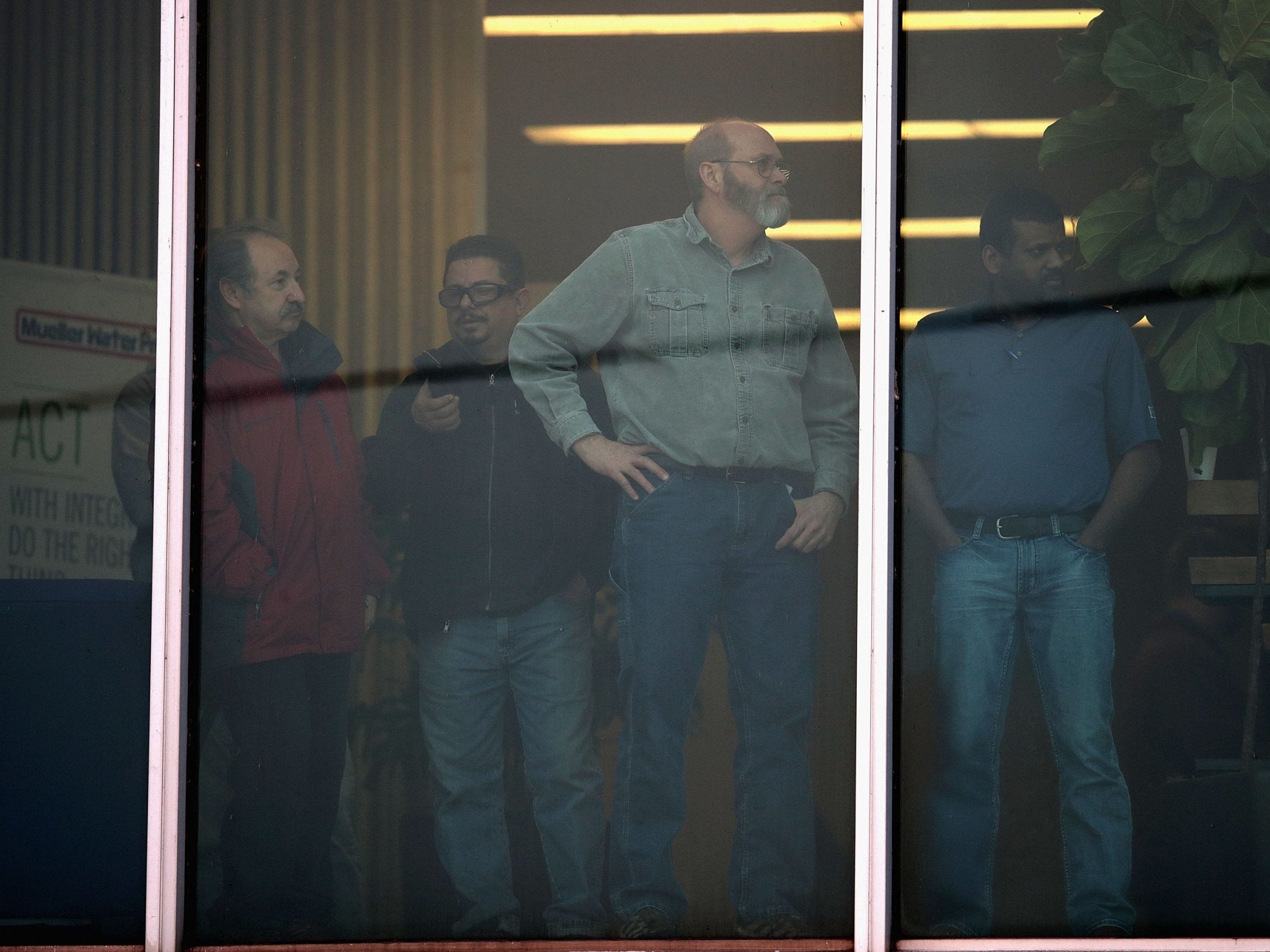 Workers look out of an office window following a shooting which killed five people and injured five police officers at the Henry Pratt Company in Aurora, Illinois, US, on 15 February, 2019.