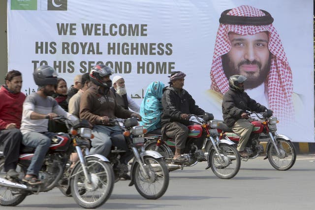 Pakistani motorcyclists pass by a banner welcoming Saudi Arabia's Crown Prince Mohammed bin Salman, displayed on the occasion of his visit in Lahore, Pakistan, on Saturday 16 February 2019.