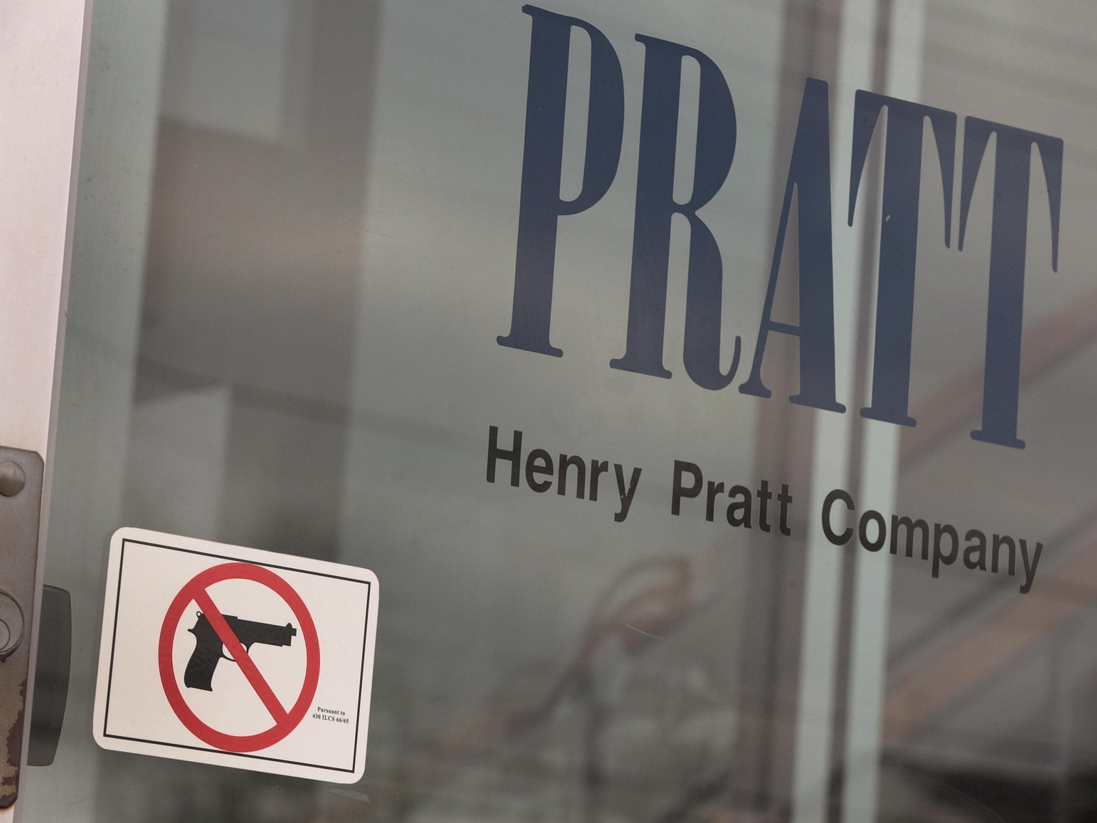 A sign on the front door of the Henry Pratt Company office shows that guns are not allowed in the building