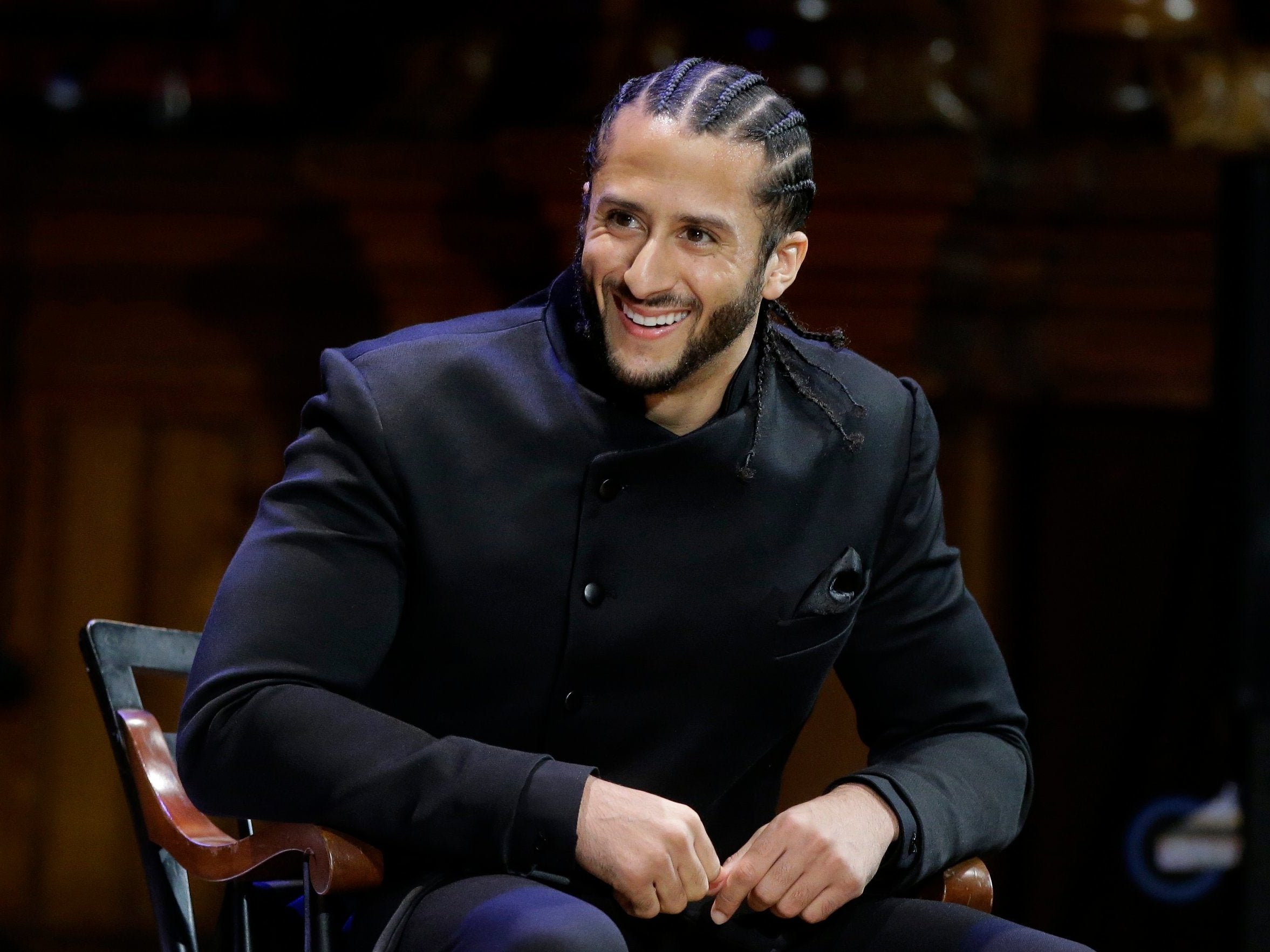 Former NFL football quarterback Colin Kaepernick smiles on stage during W E B Du Bois Medal ceremonies at Harvard University