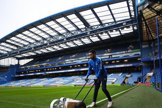 A groundkeeper prepares the Stamford Bridge pitch