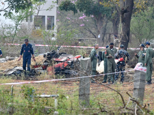 Indian Air Force personnel gather around the wreckage of one Surya Kiran 'Hawk' aircraft after two of them collided in mid-air and crashed during an air show rehearsal on 19 February 2019.