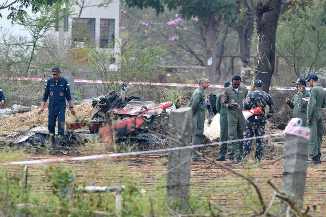 Indian Air Force personnel gather around the wreckage of one Surya Kiran 'Hawk' aircraft after two of them collided in mid-air and crashed during an air show rehearsal on 19 February 2019.