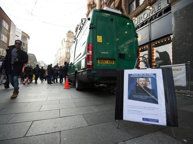 People walking past an unmarked police van during a trial of facial recognition in central London