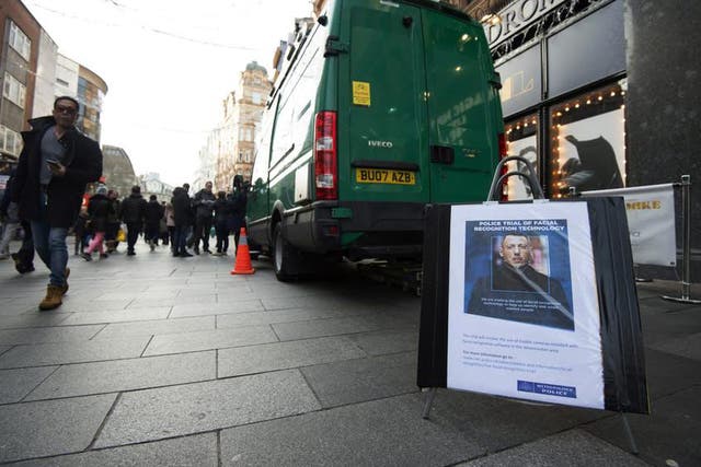 People walking past an unmarked police van during a trial of facial recognition in central London