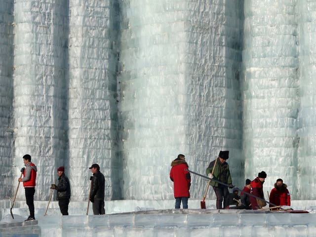 Workers clear up the melting ice at Harbin's ice and snow sculpture festival