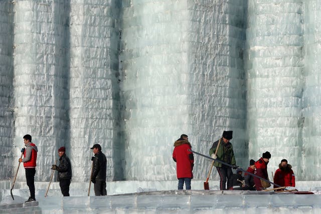 Workers clear up the melting ice at Harbin's ice and snow sculpture festival