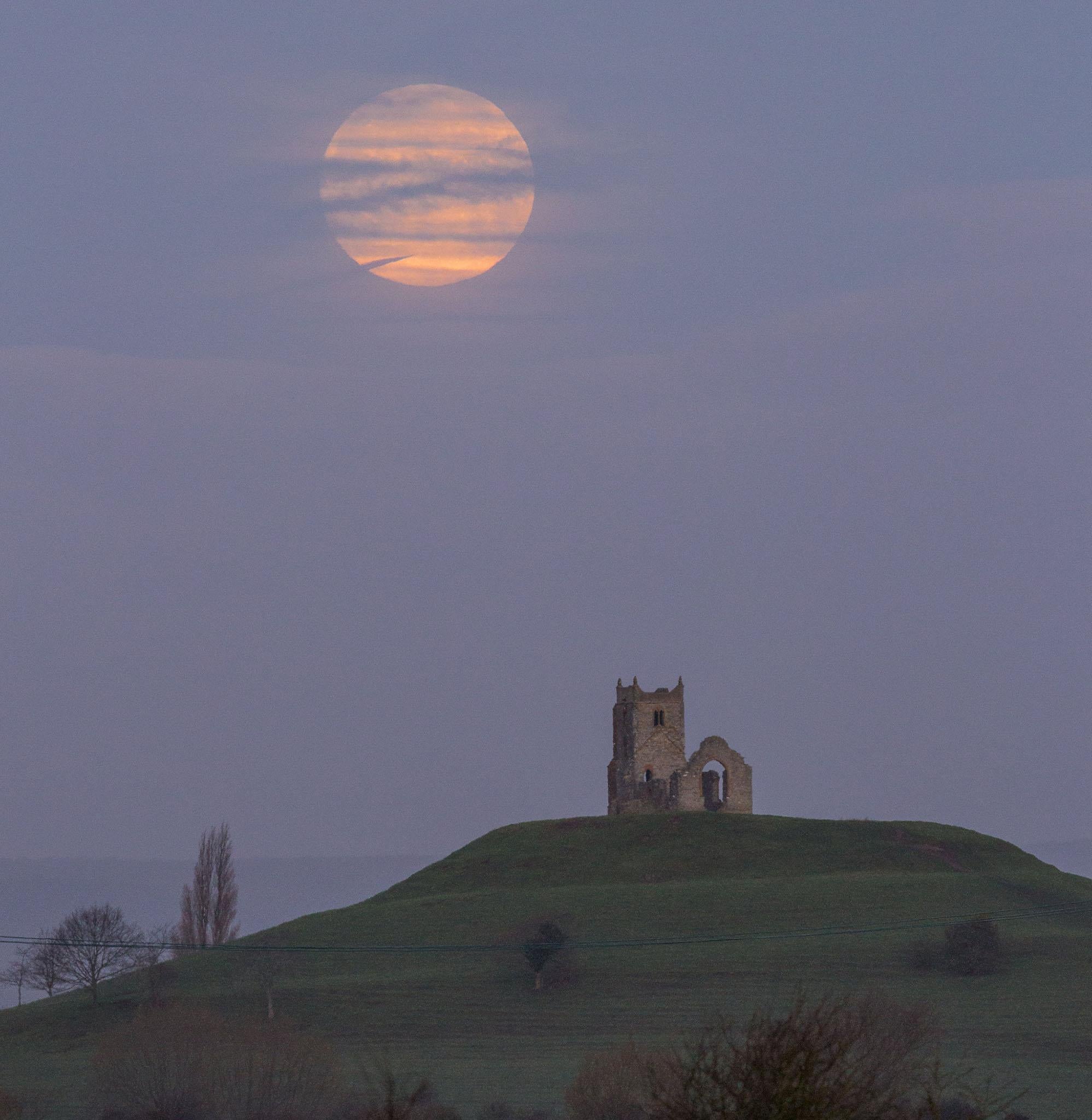 The moon setting over Burrow Mump at Burrowbridge in Somerset this morning