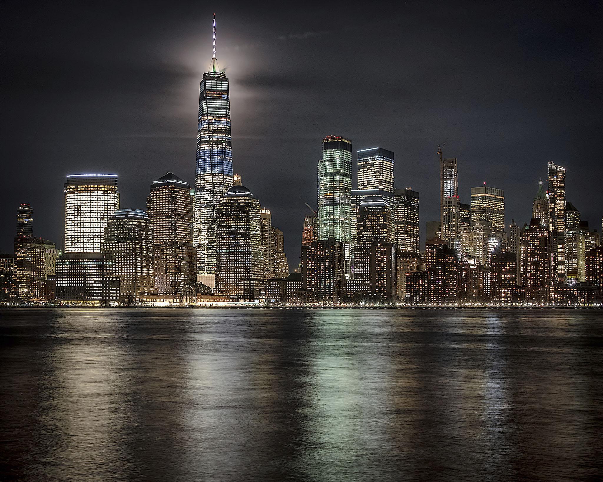 The moon lights up the sky behind One World Trade Center in New York