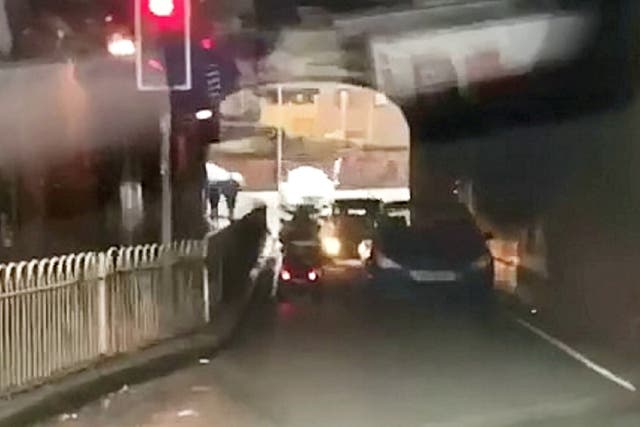 Elderly man filmed driving mobility scooter through red light then into oncoming traffic under bridge in Worcester, West Midlands.