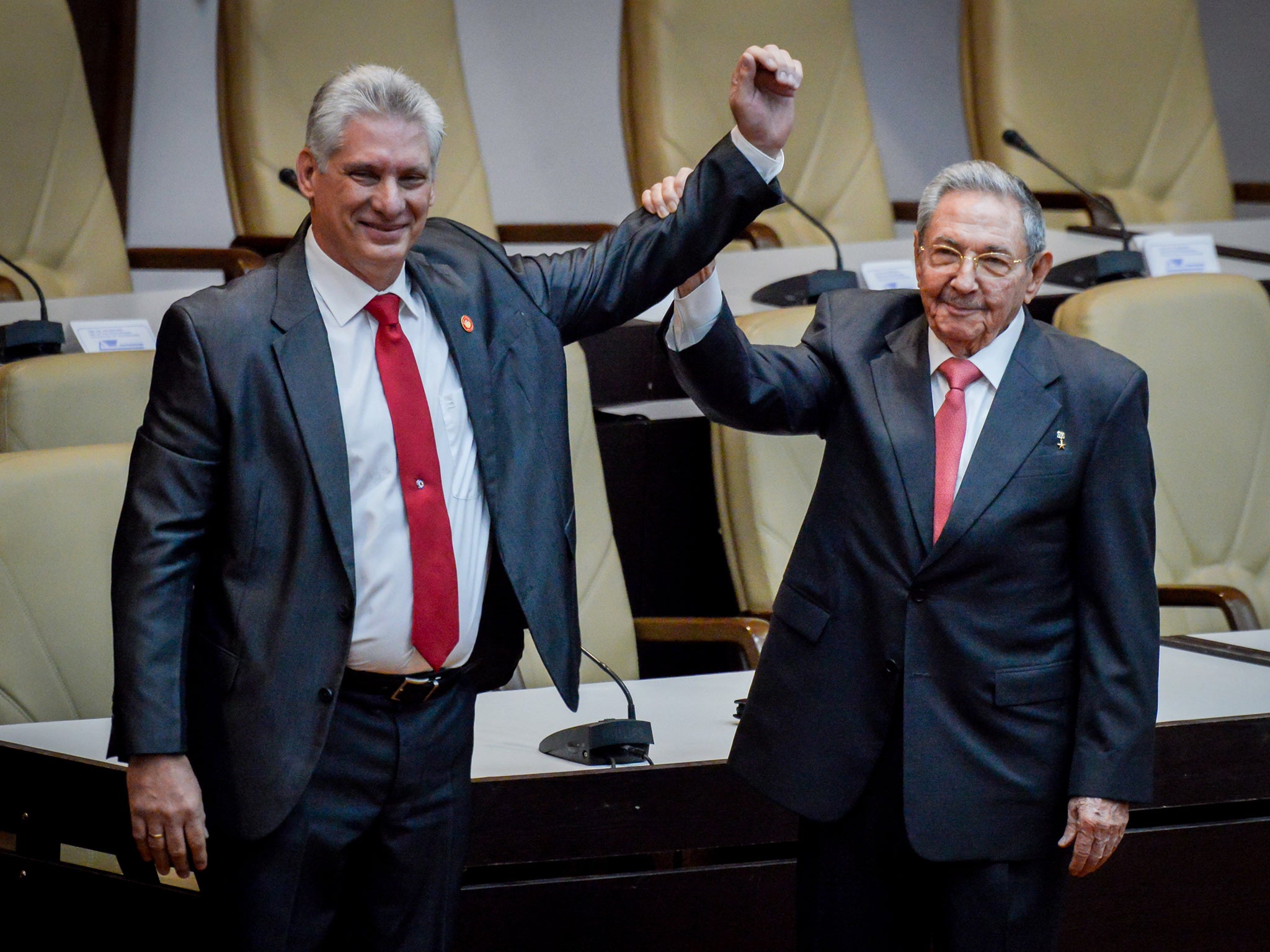 Former Cuban president Raul Castro raises the arm of newly elected president Miguel Diaz-Canel. Castro stepped down after 12 years in power in 2018 (Getty)