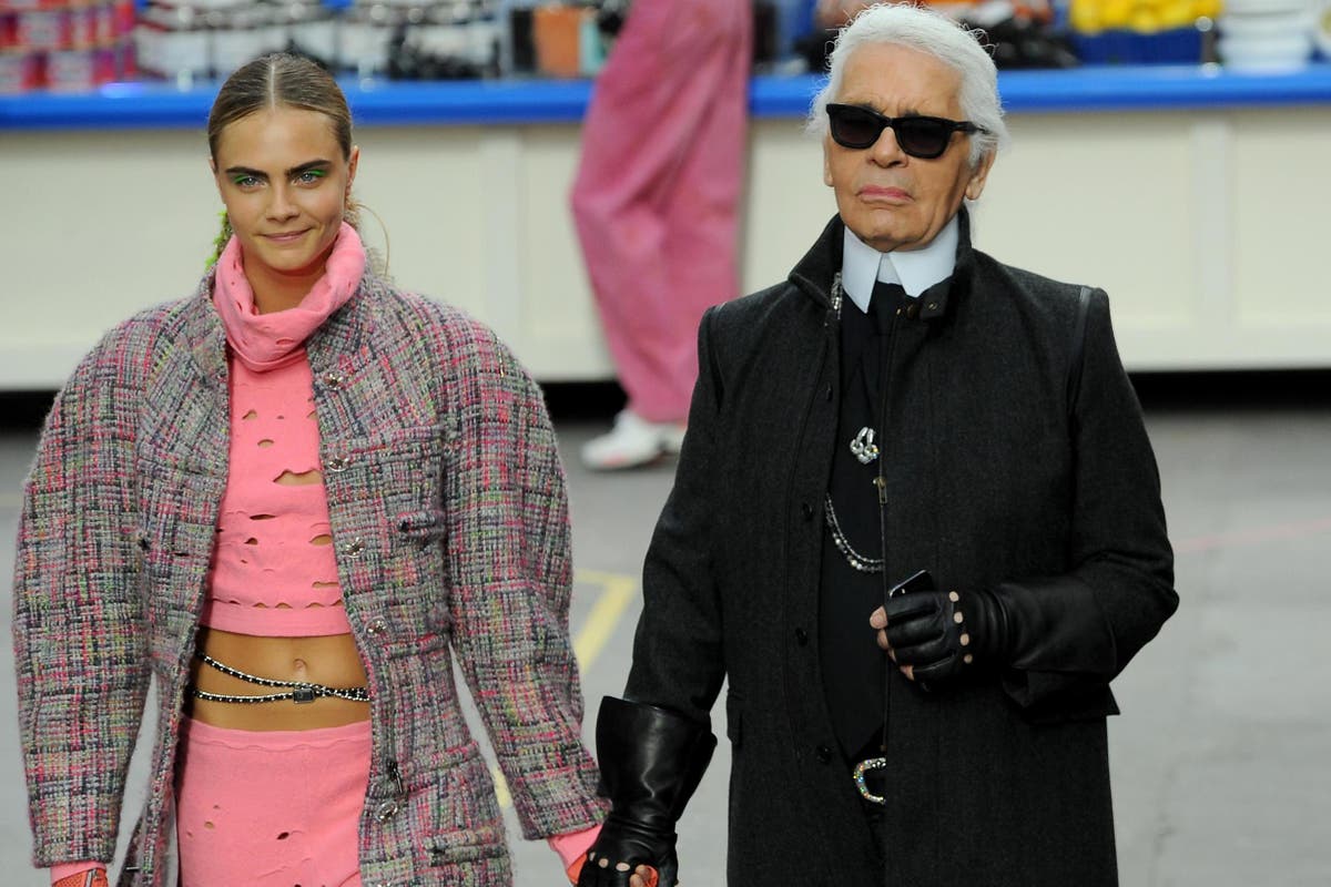 Cara Delevingne puckers up with Karl Lagerfeld as she joins