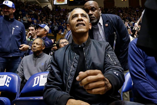 Former President Barack Obama joins fans during an NCAA college basketball game between Duke and North Carolina in Durham, N.C., Wednesday, Feb. 20, 2019.