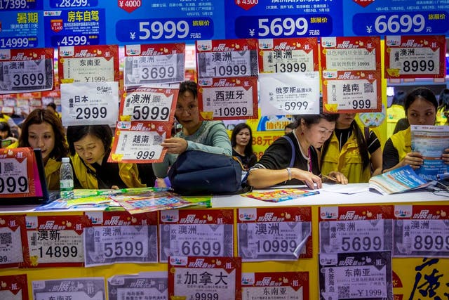 People browse travel packages on sale at 2018 Guangzhou International Travel Fair in China, where the government blocked millions of people from flying last year