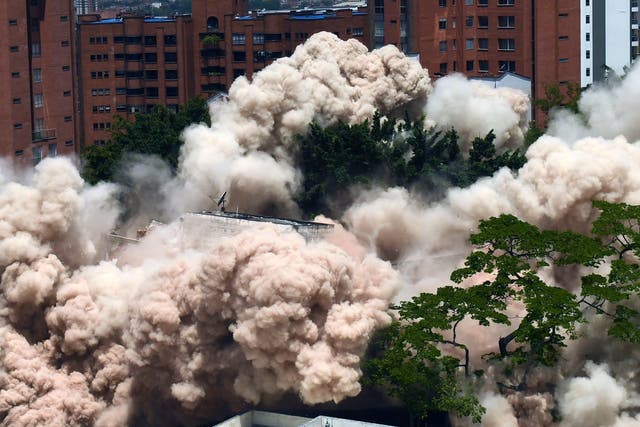 A dust cloud rises as the Monaco building in Medellin is demolished