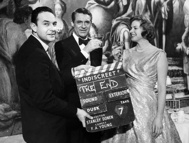 Director Stanley Donen holds up the final clapperboard as Cary Grant