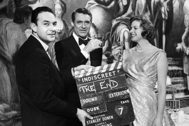 Director Stanley Donen holds up the final clapperboard as Cary Grant