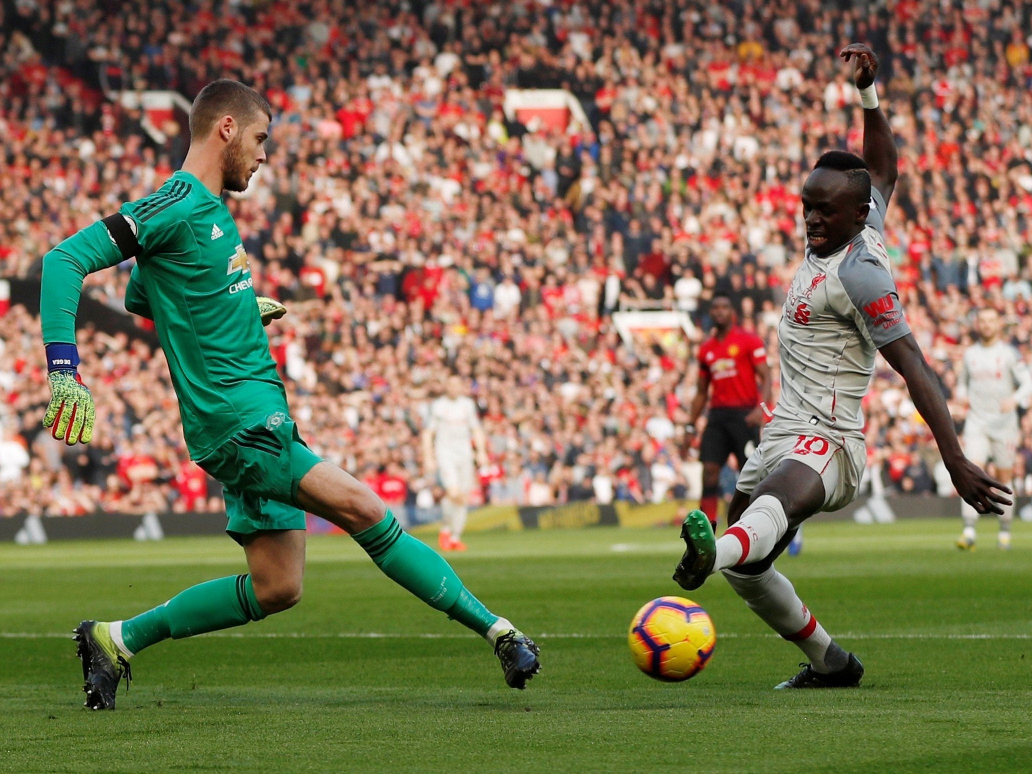 David De Gea and Sadio Mane challenge for the ball