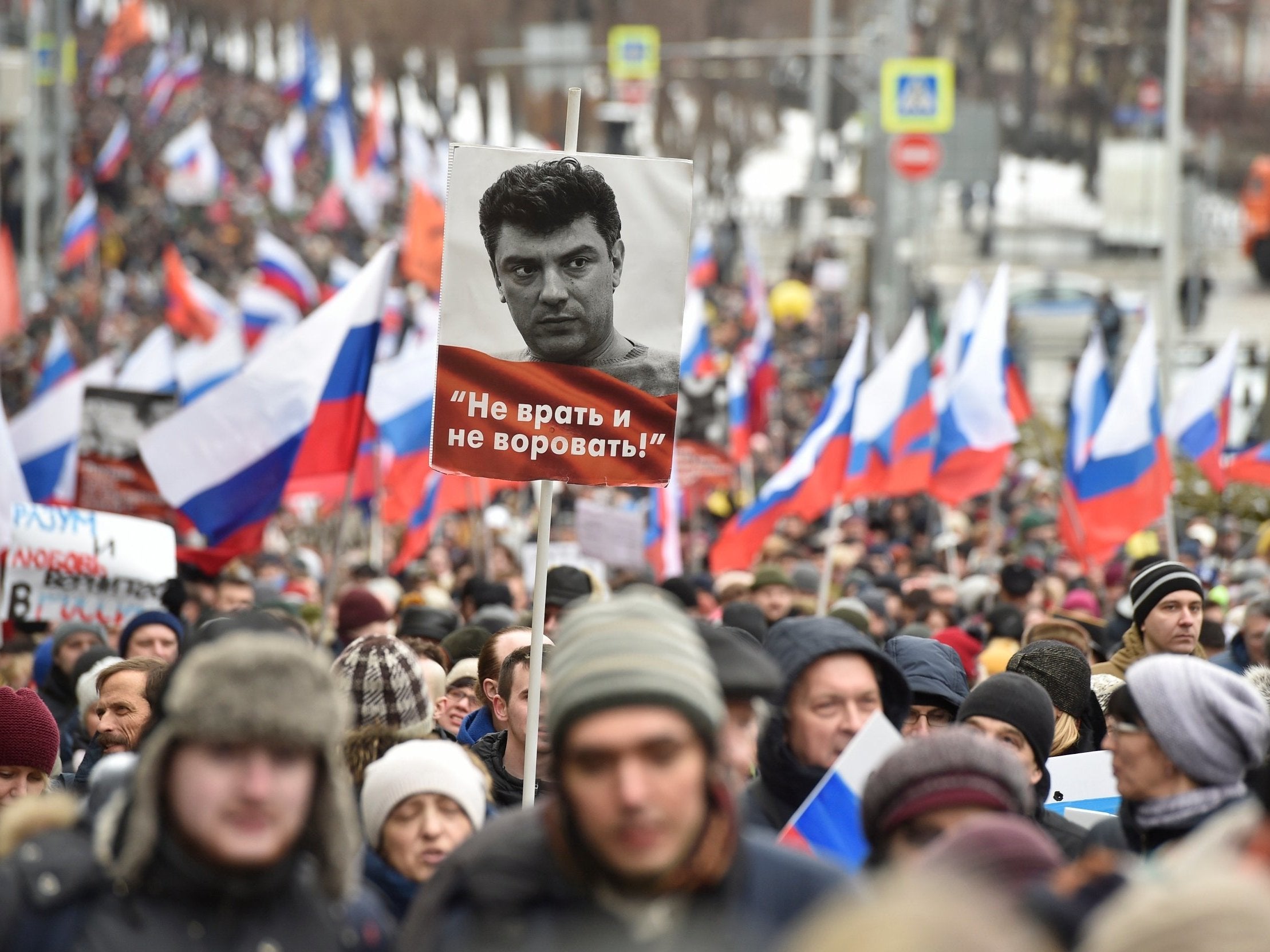 Demonstrators with Russian flags and a portrait of Boris Nemtsov, with words reading 'Do not lie, do not steal', march in Moscow, Russia