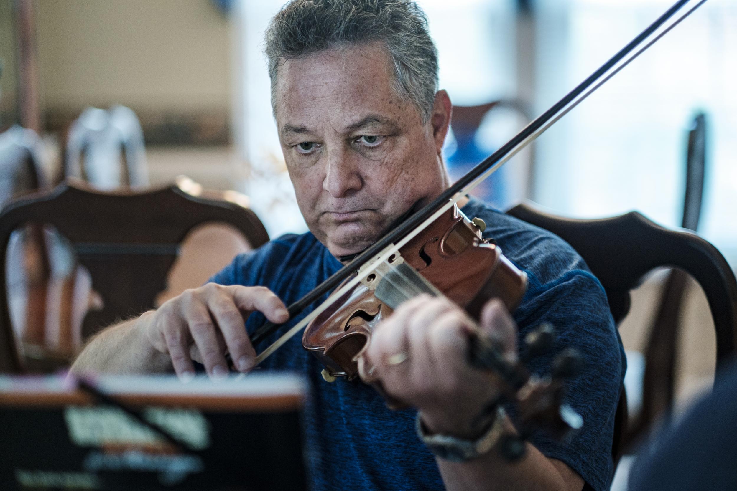Tom plays the violin for his wife in their Virginia home (Pete Marovich/The Washington Post)